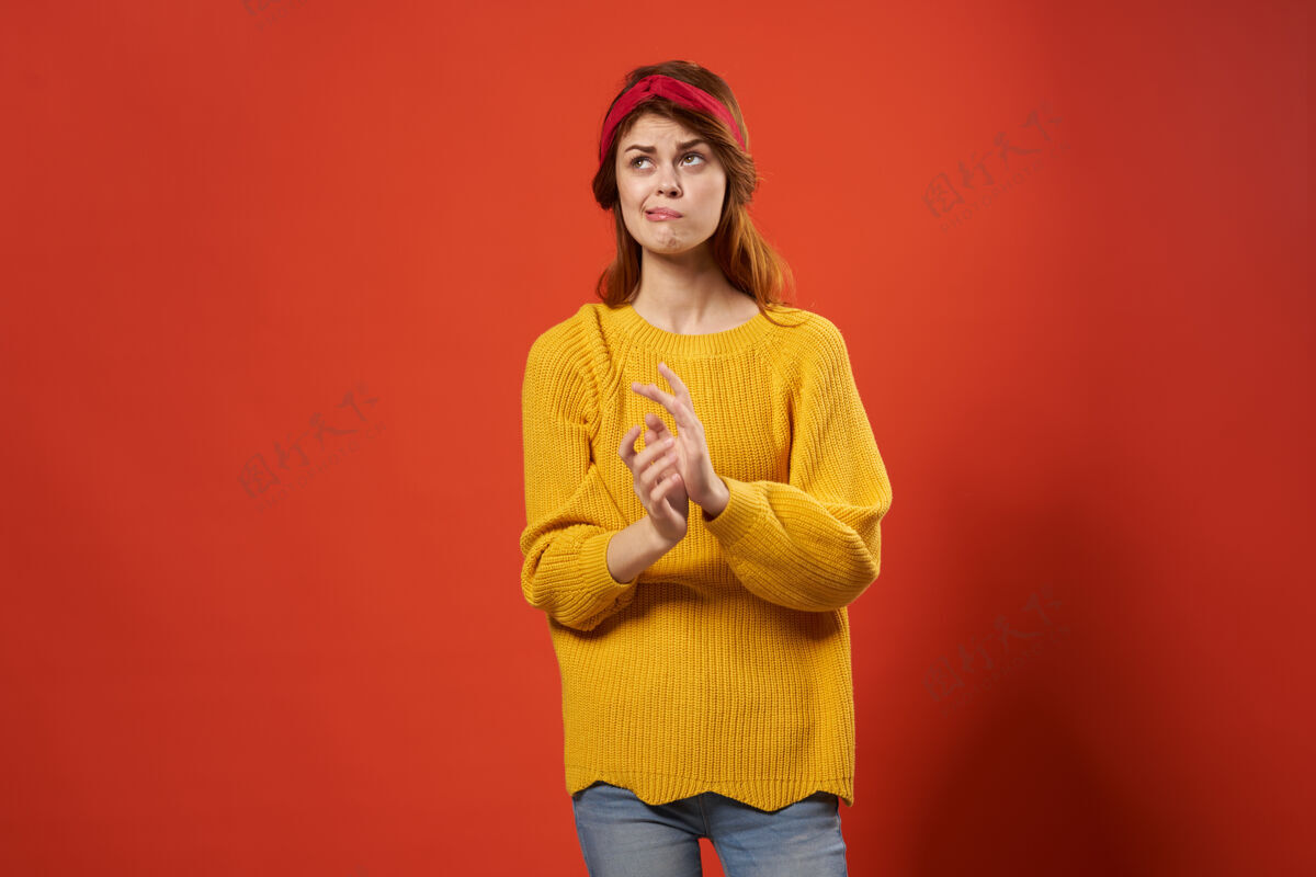 模型欢快的红发女人穿着黄色毛衣情绪街头时尚红墙配件嬉皮士波西米亚