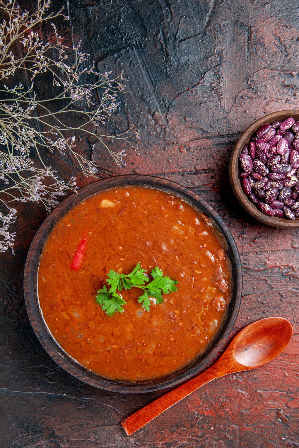 西红柿经典番茄汤的垂直视图在一个棕色的碗豆和勺子上混合颜色的桌子镜头碗美味餐厅