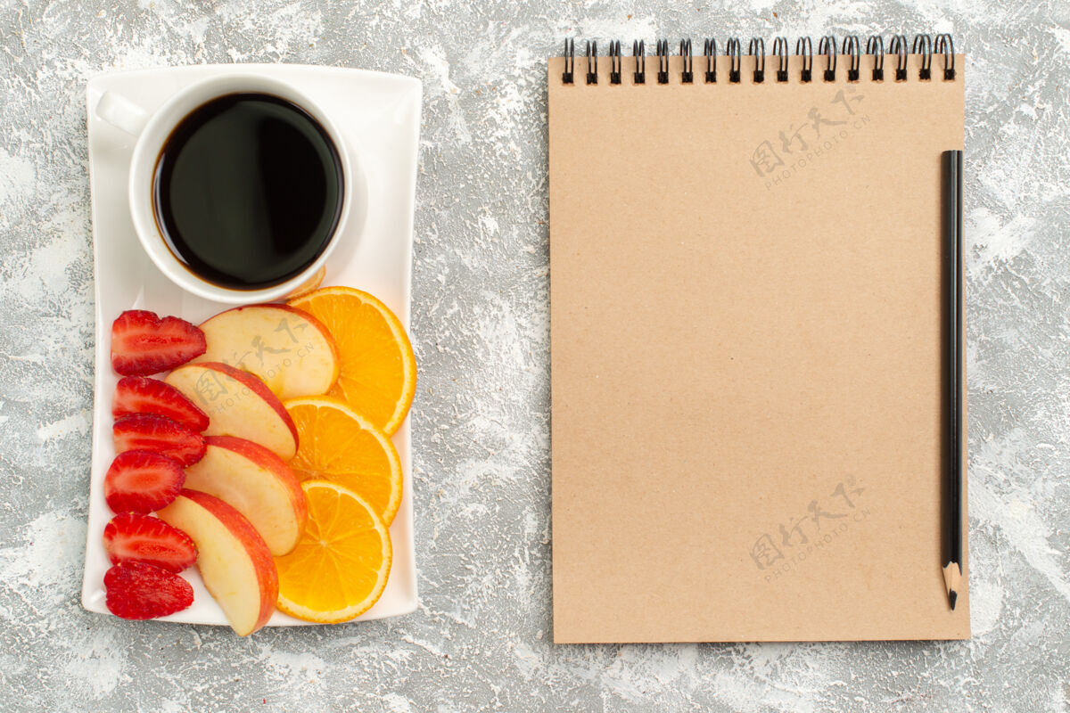 笔记本俯瞰一杯咖啡 配切片苹果 橙子和草莓 背景为白色水果 成熟 新鲜 醇厚水果背景橘子