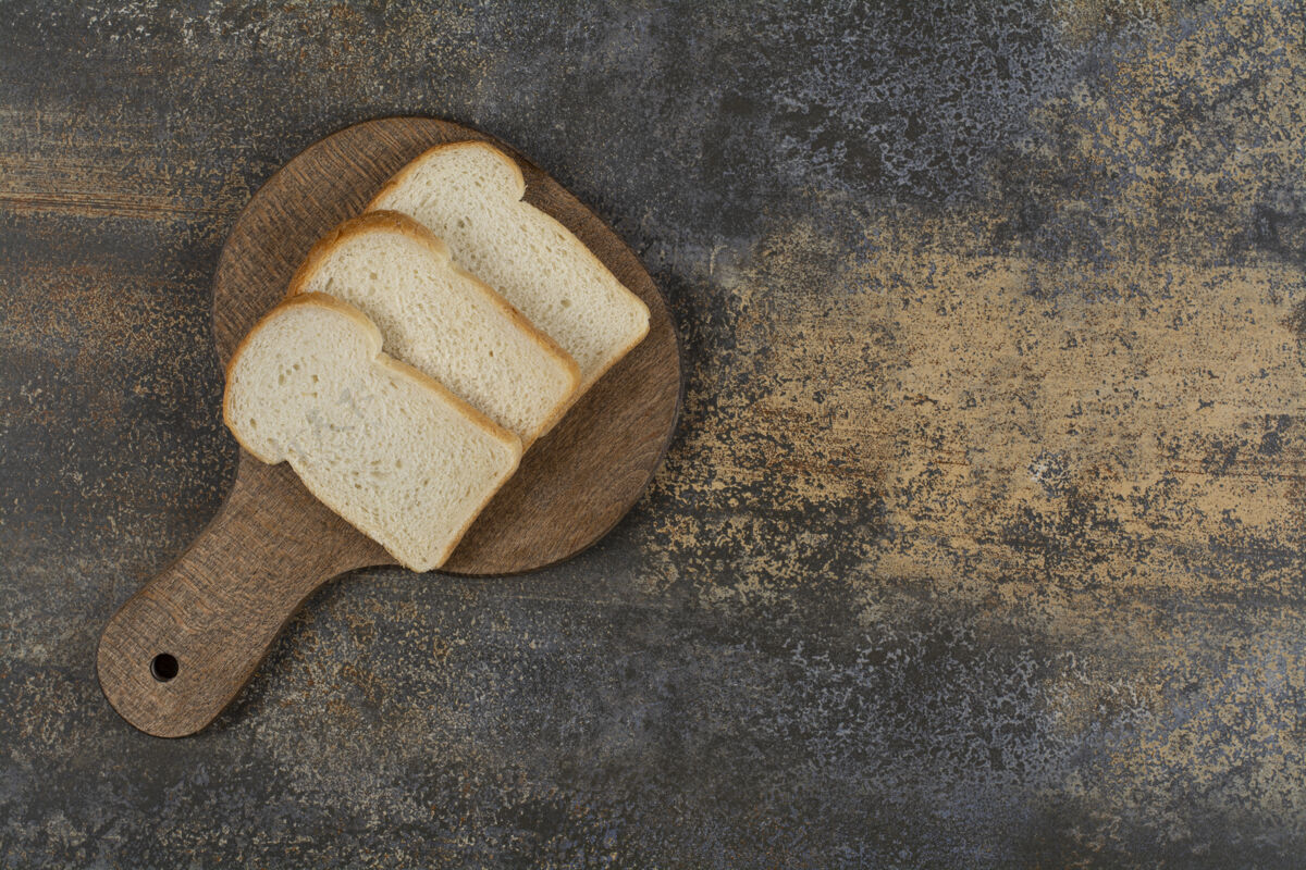 小麦在木砧板上放几片白吐司面包新鲜面包皮切片