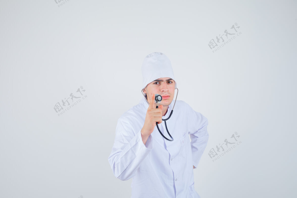 检查医生 一个十几岁的男孩拿着听诊器 穿着制服假装在检查心跳 看上去很严肃 正视图青少年治疗人