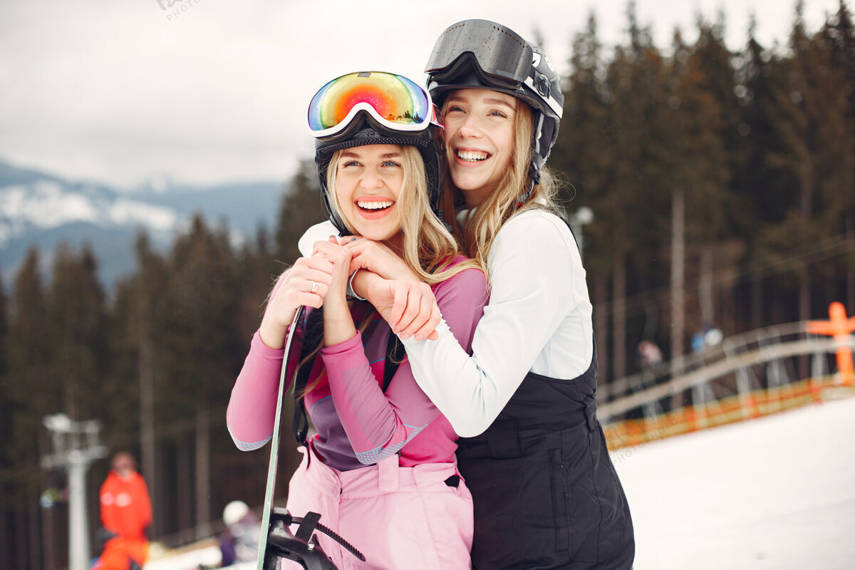 白色穿着滑雪板套装的女人在山上的运动员手拿滑雪板在地平线上关于运动的概念高山人人