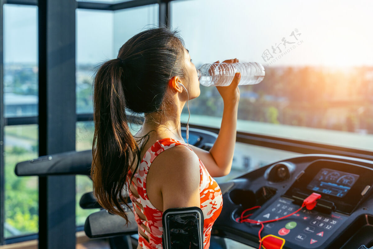 放松年轻女子在健身房喝水运动概念运动后设备活动