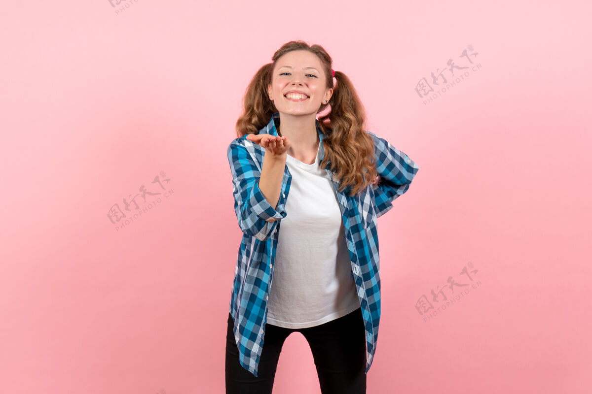 格子正面图身着蓝色格子衬衫的年轻女性 粉色背景上的快乐表情青春情感女孩儿童模特时尚情感年轻的女性孩子