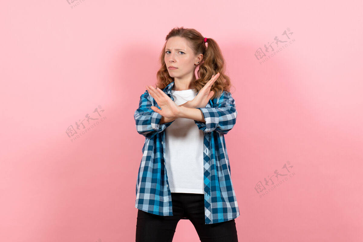 衬衫正面图身着蓝色格子衬衫的年轻女性在粉色背景上摆姿势青春情感女孩儿童模特时尚人姿势肖像