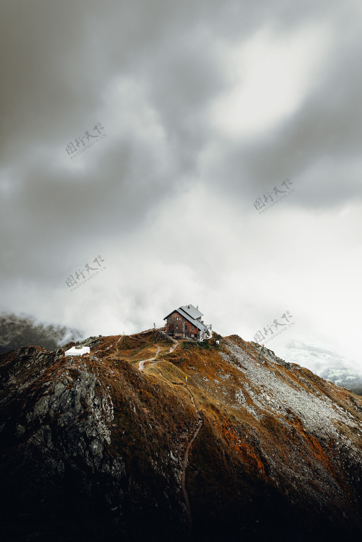 房子白色和棕色的房子在棕色的山顶白云下建筑小屋山