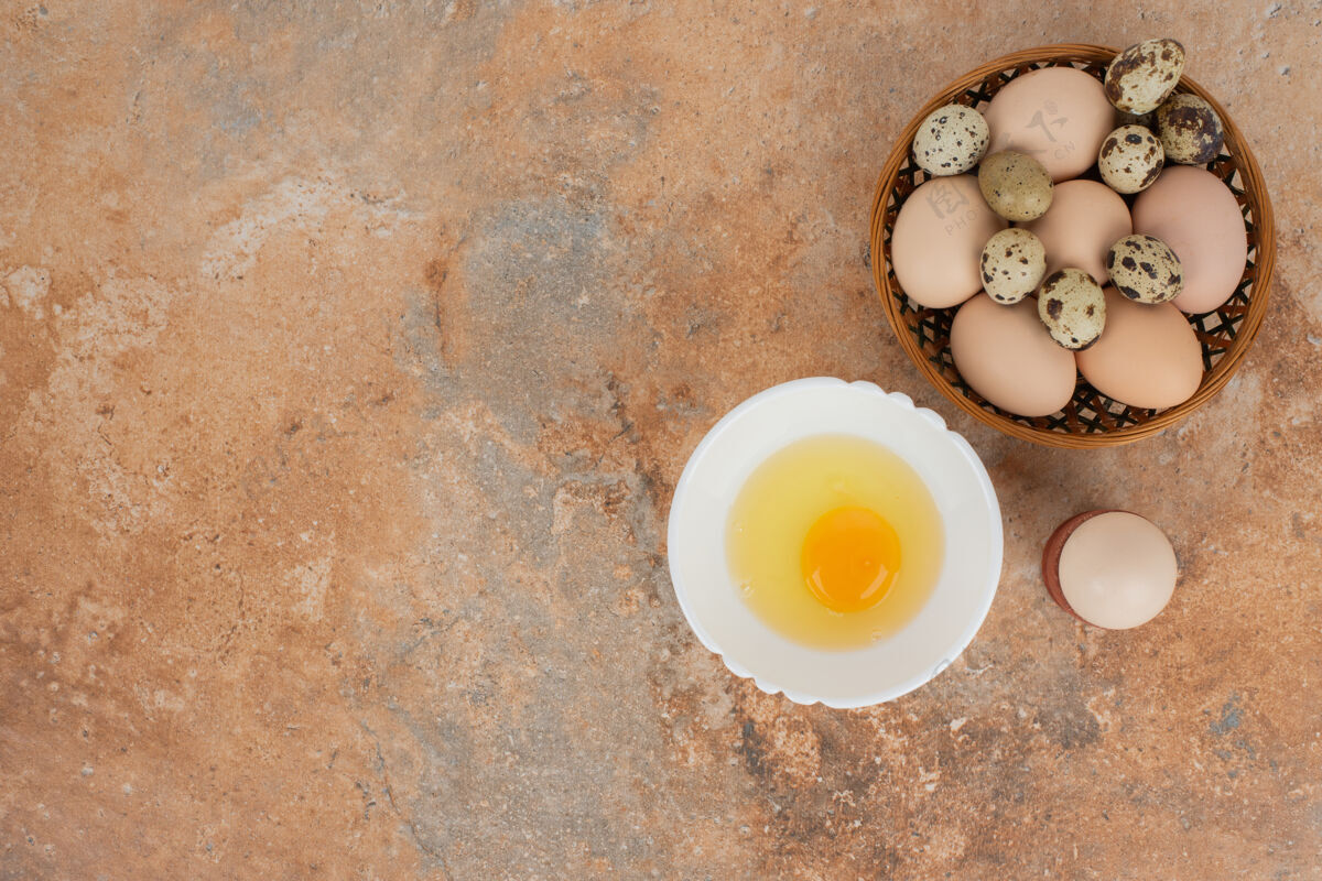 食物大理石桌上的盘子上有几个鸡蛋和生鸡蛋鸡蛋蛋黄蛋白质