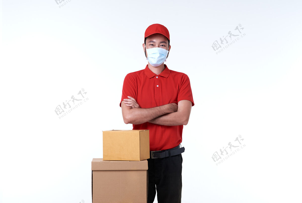 男性亚洲送货员戴着红色制服的口罩和白色包裹盒成人盒子衣服