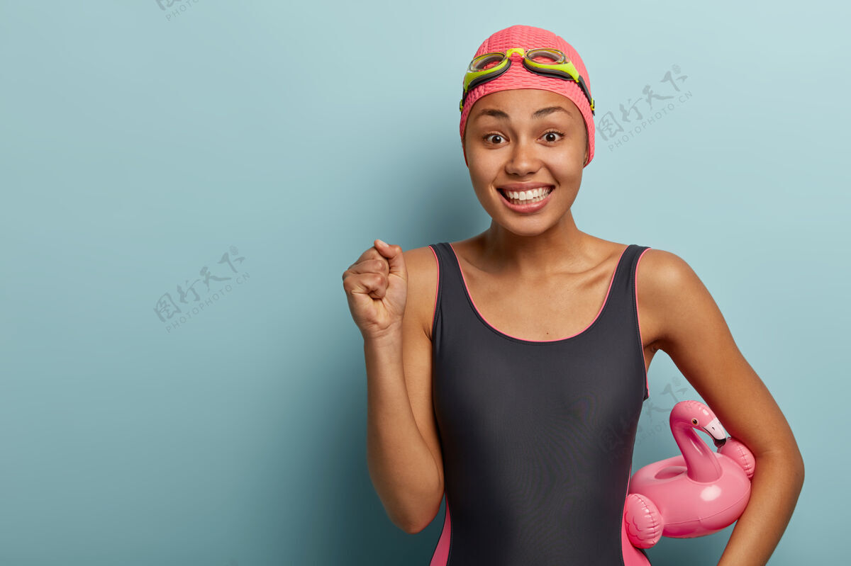 姿势快乐的女游泳运动员戴着护目镜摆姿势游泳积极女性