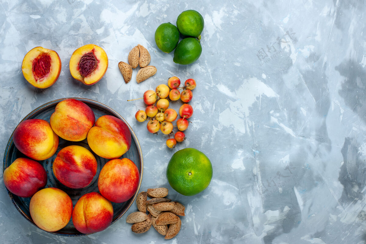饮食浅白色书桌上有新鲜的桃子和美味的夏天水果和橘子生的醇香维生素