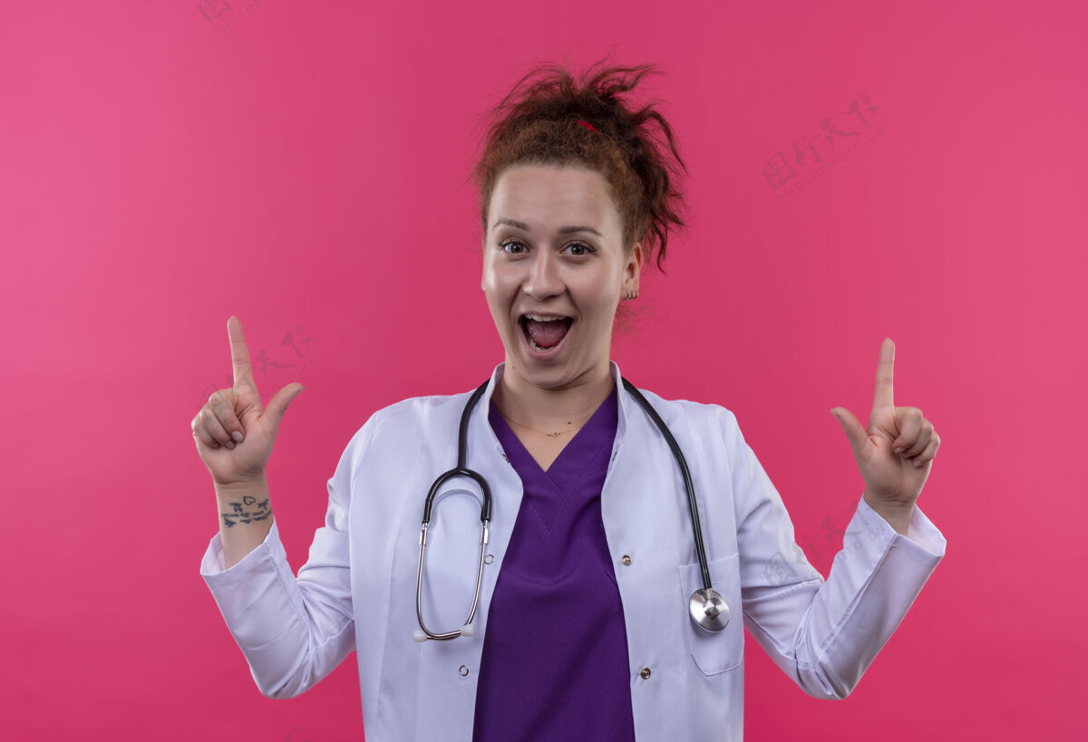 指着身穿白色外套 带听诊器的年轻女医生走了出来 惊讶地用食指指着粉色的墙壁外套退出惊喜