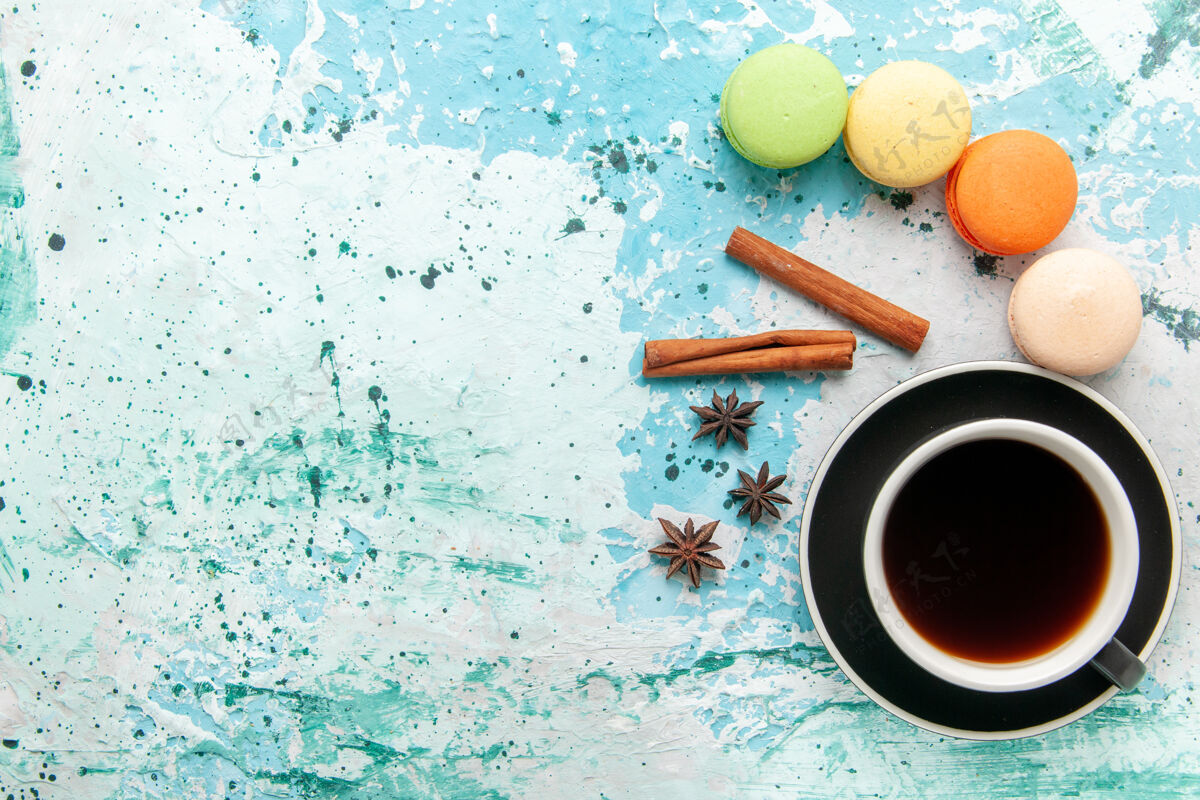 糖俯瞰一杯茶 蓝色表面有法国马卡龙马卡龙饮料热的