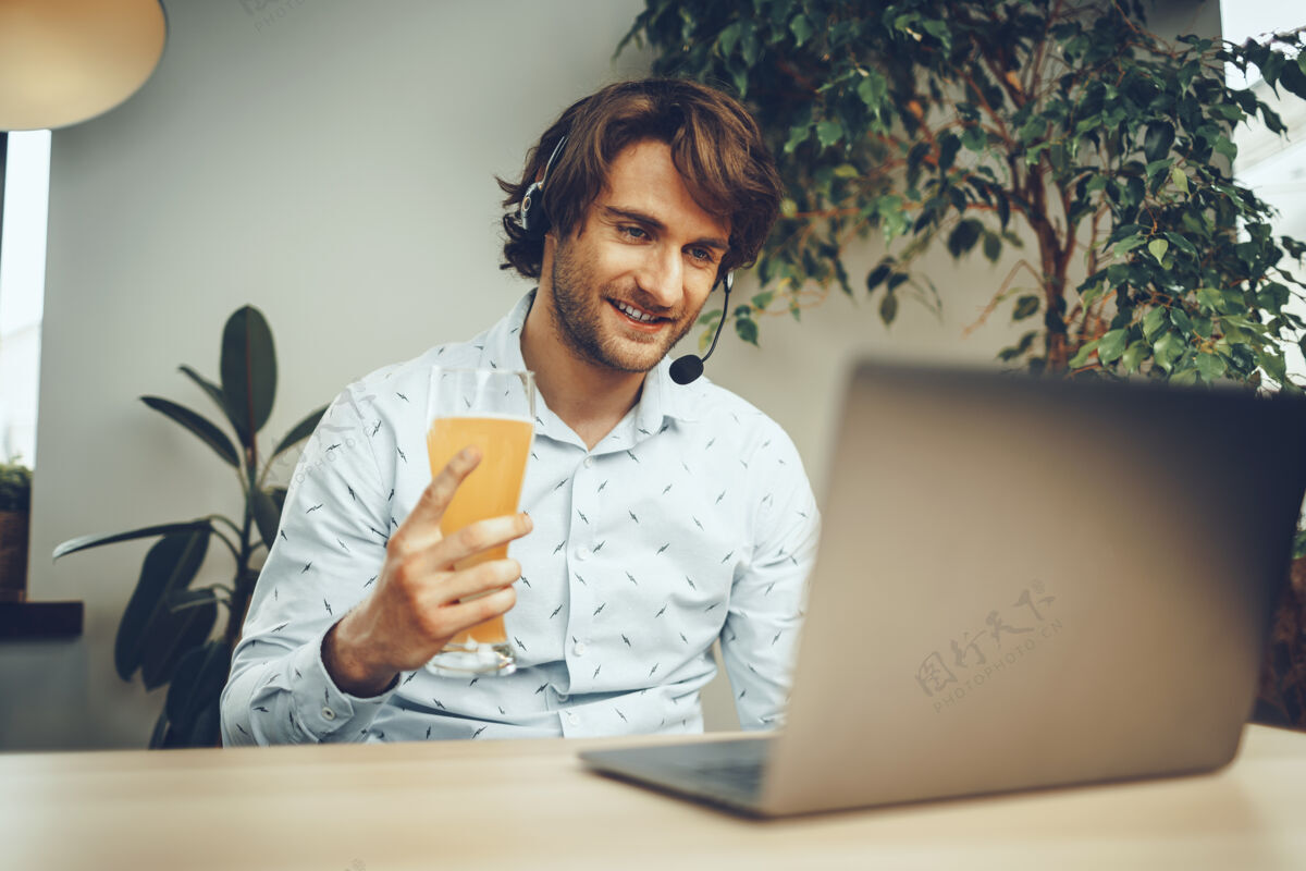 游戏大胡子男人一边喝啤酒一边用笔记本电脑年轻人男人成年人