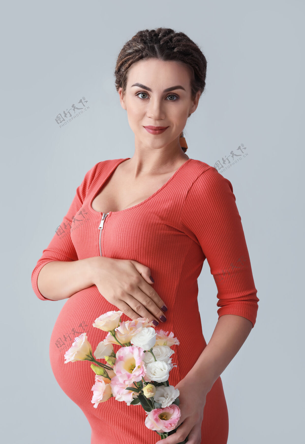 腹部美丽的孕妇 灰色背景上有鲜花女性健康漂亮