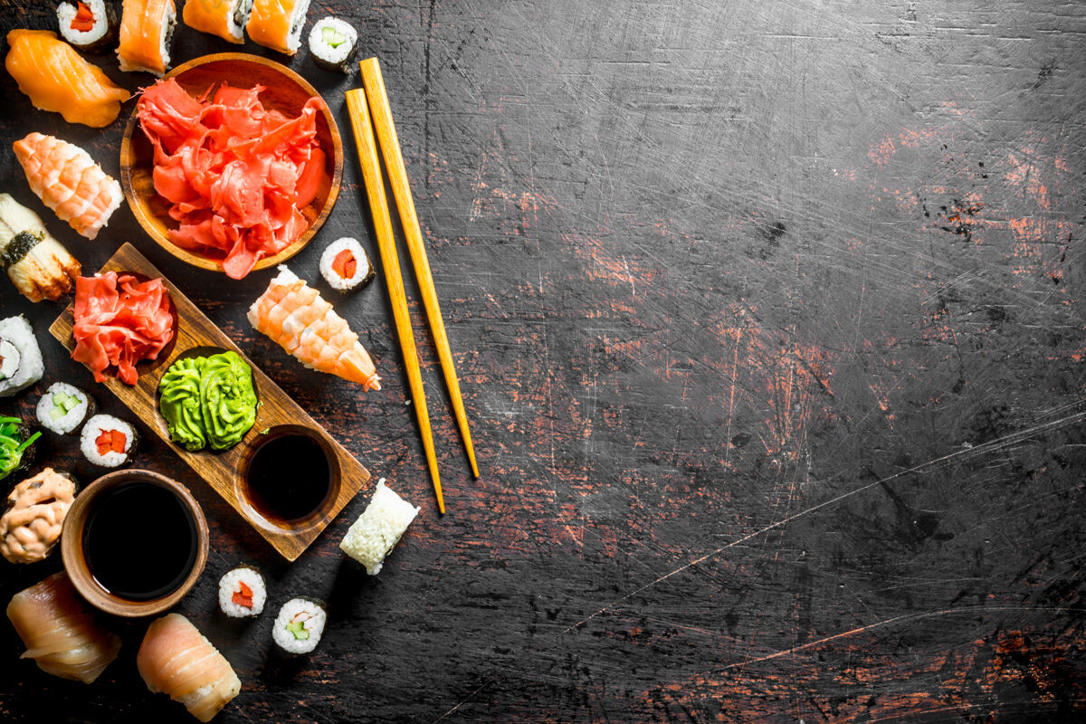 芥末一套传统的日本寿司和带有腌姜和酱油的面包卷放在乡村的桌子上准备大米餐厅