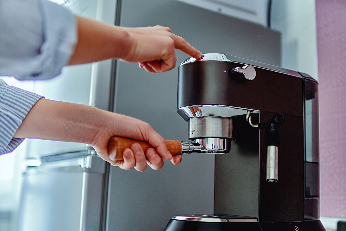 蒸汽女性的手拿着过滤器 在家里用现代化的咖啡机煮新鲜芳香的咖啡休息咖啡机浓缩咖啡