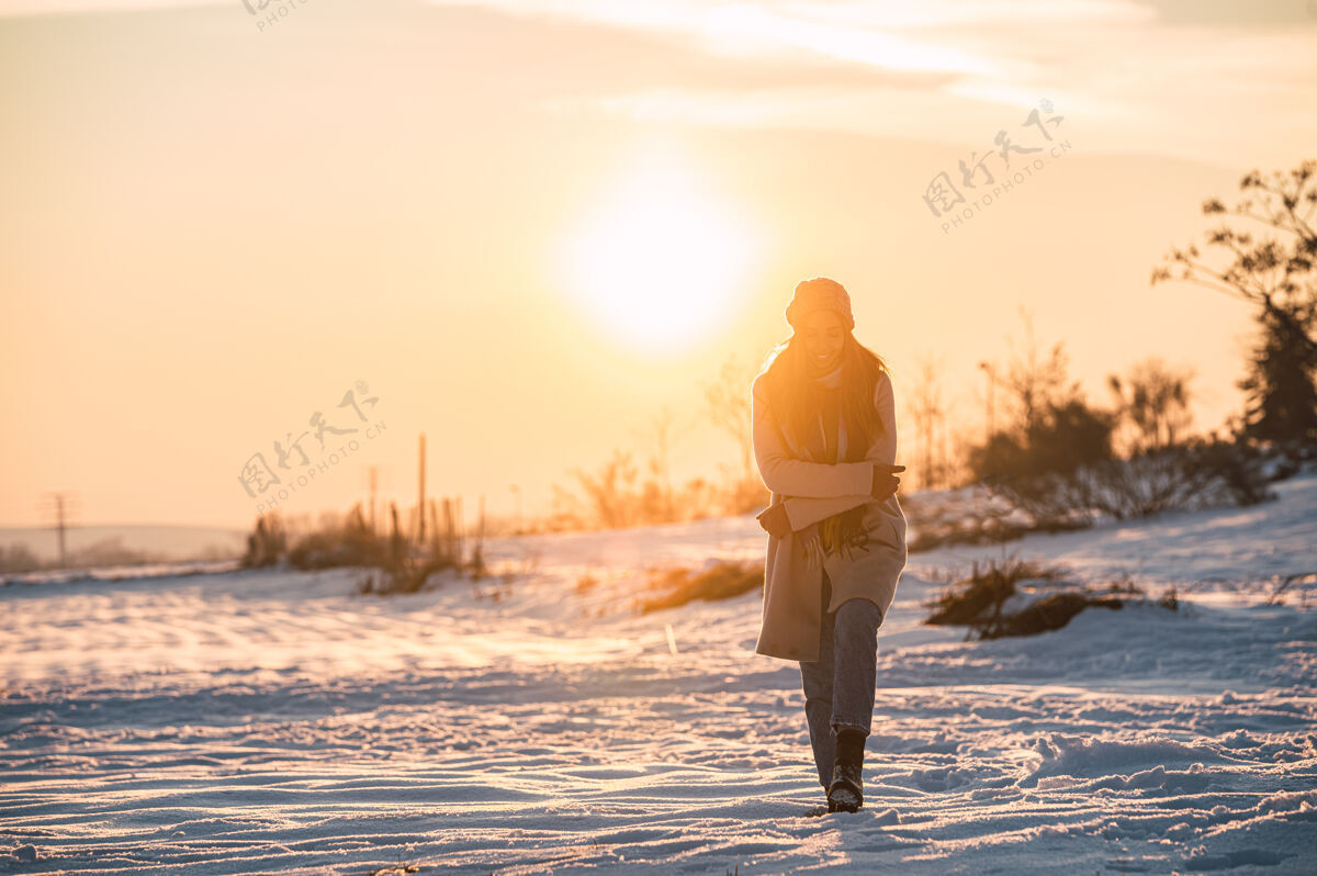 天气夕阳时分 冬日乡间 一身暖洋洋的快乐少女 在新鲜的白雪上漫步内容寒冷时尚