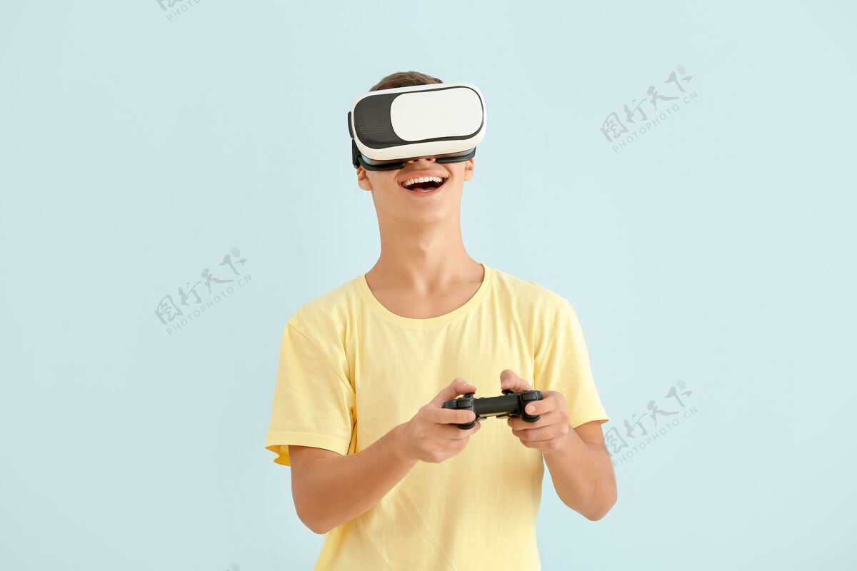 现实戴着虚拟现实眼镜玩电子游戏的少年男孩男孩虚拟现实耳机游戏