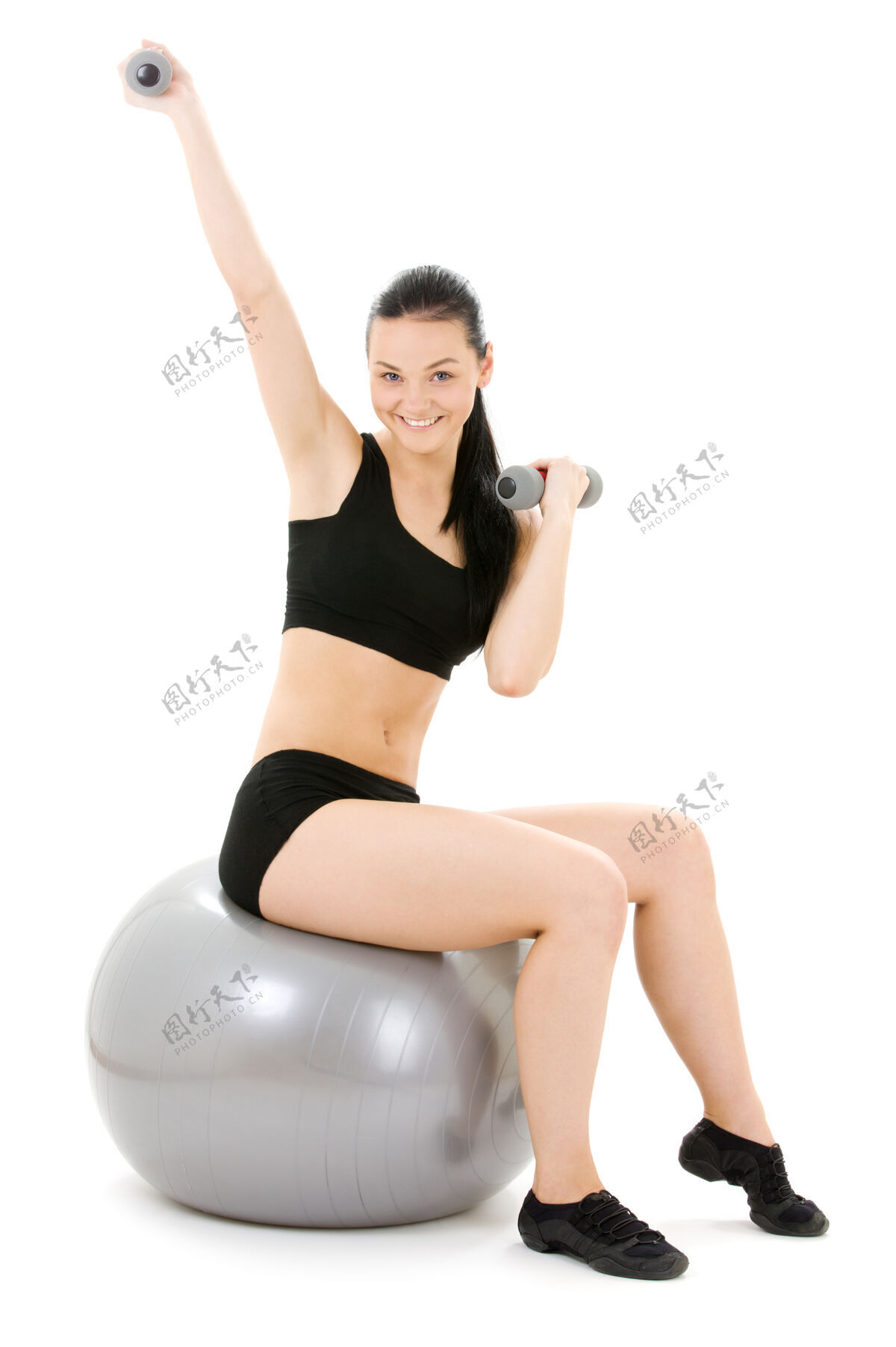 女士可爱的健身教练与普拉提球哑铃吸引力平衡体操