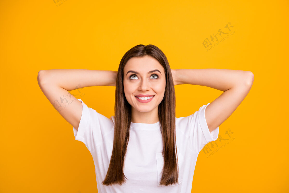 女性化特写照片相当冷静的女士好心情思考抬头看空空间手臂后面的头高兴的牙齿穿休闲白色t恤隔离生动的黄色墙壁欢呼积极时尚