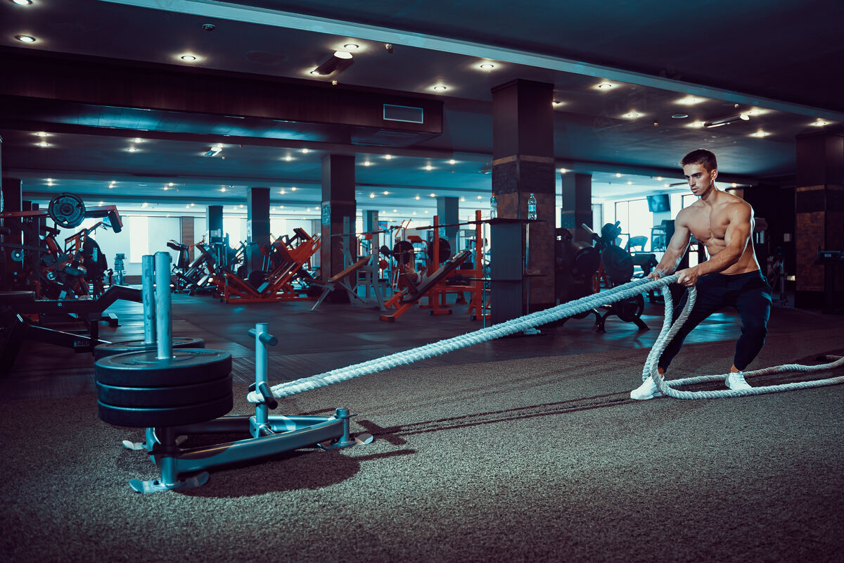 力量健身员在健身房用战绳锻炼健身成人努力
