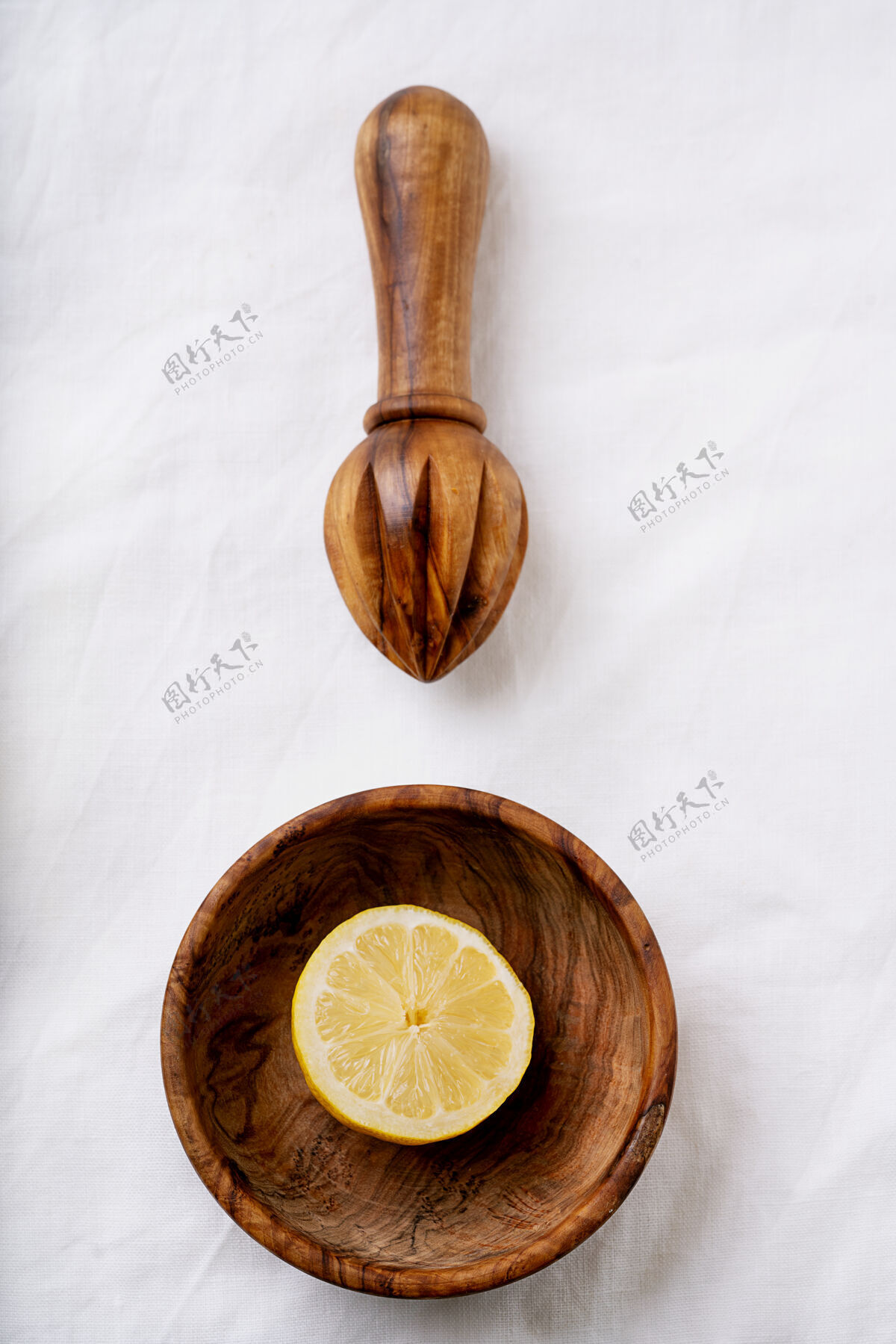 成熟柠檬在木制碗与木制挤压器切成两半白色织物表面顶视图平铺复制空间刷新加工配料