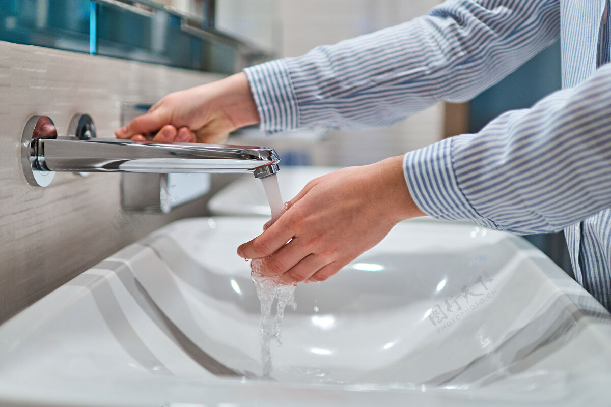 微生物在浴室的流水下洗手的人手指消毒剂泡沫