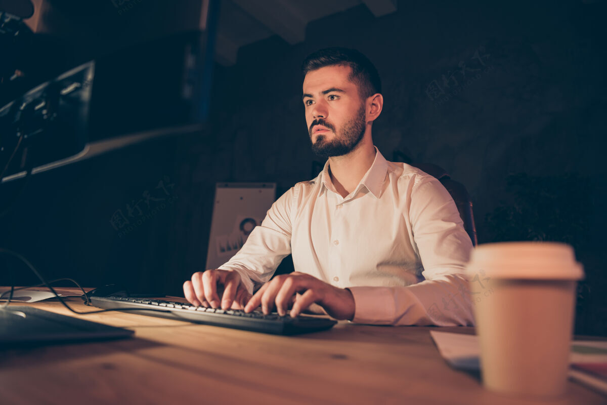 加班商人的肖像坐在电脑桌上工作打字电脑年轻人