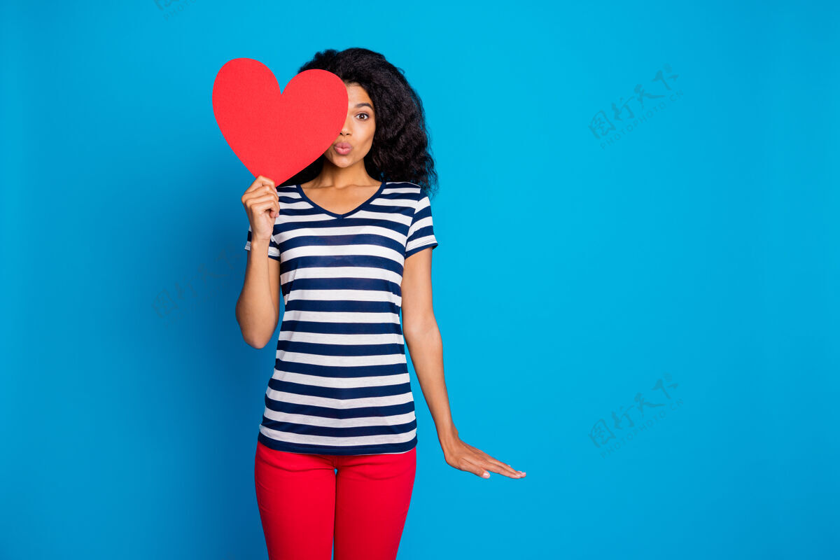 非洲女人亲吻你的照片穿条纹t恤用大红心遮住半张脸积极大女人