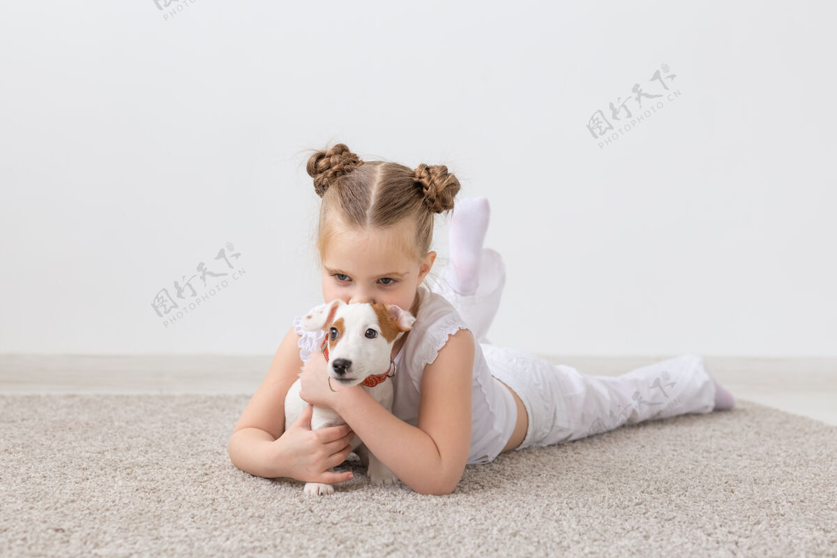 可爱小女孩在地板上玩小狗杰克罗素地板女孩衬衫