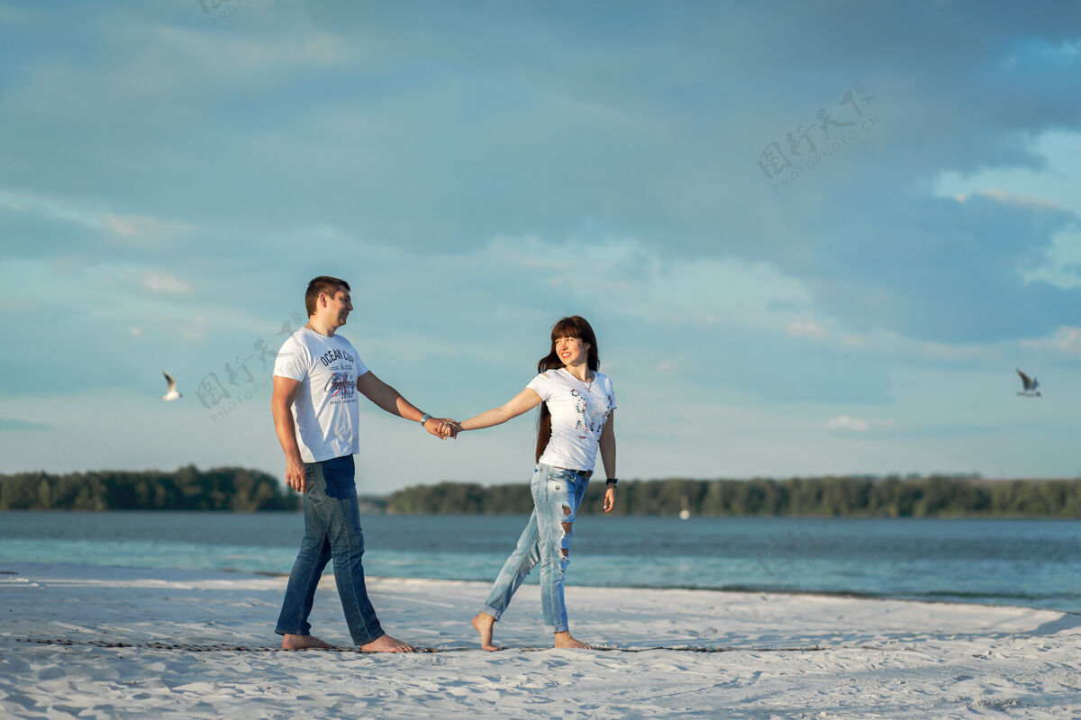 白天一对年轻情侣在沙滩浪漫约会拥抱婚礼家庭