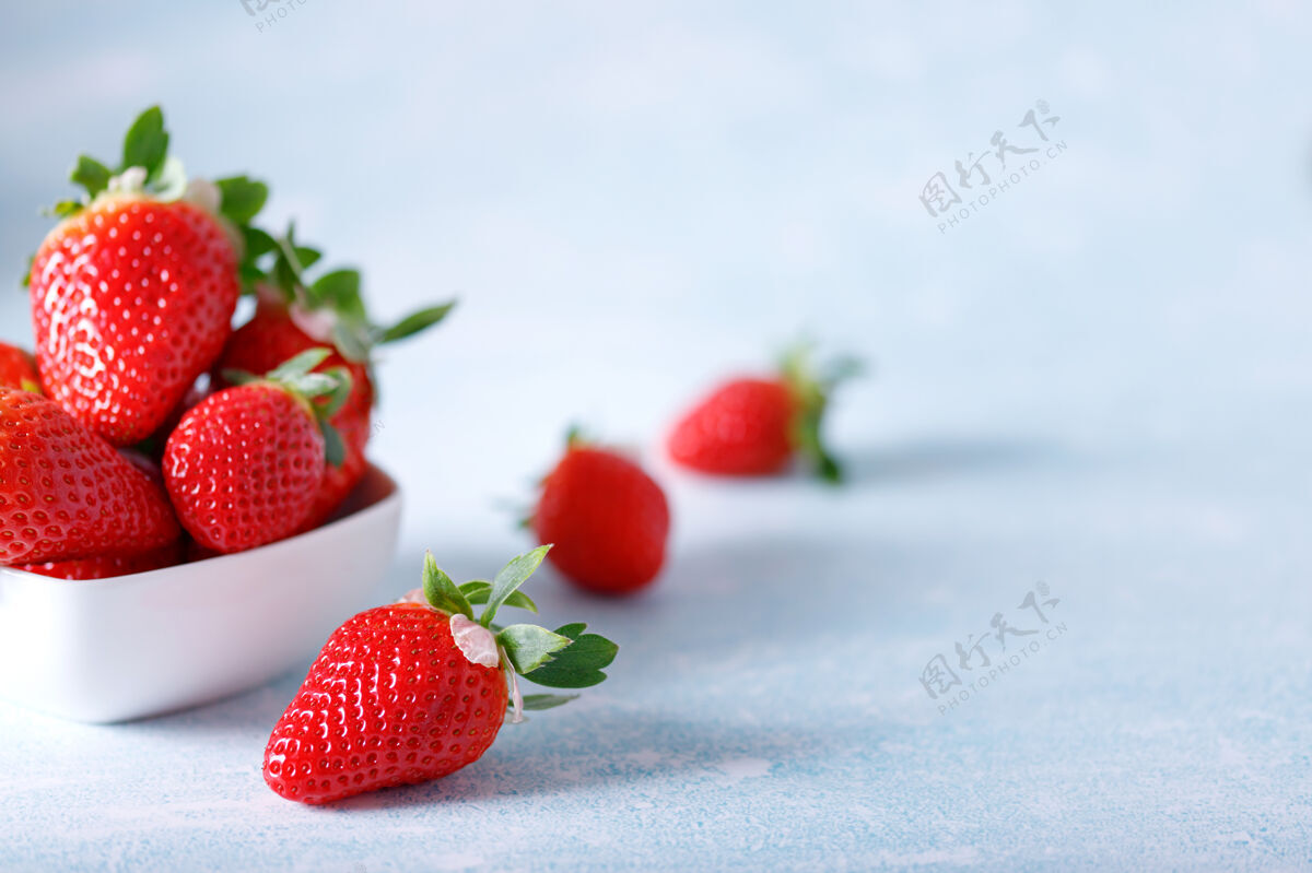 营养生的红色有机草莓在蓝色的背景上一串串美味健康