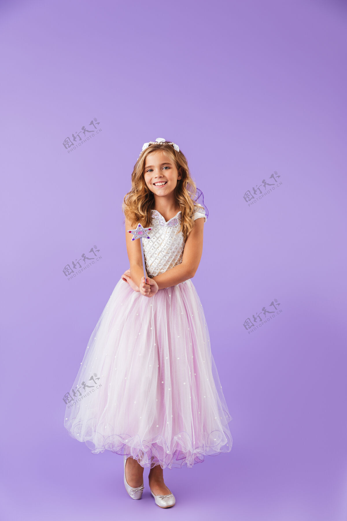 魔术一个微笑的漂亮女孩的全身肖像 穿着公主裙 隔着紫罗兰色的墙 手持魔杖美丽吸引力无辜