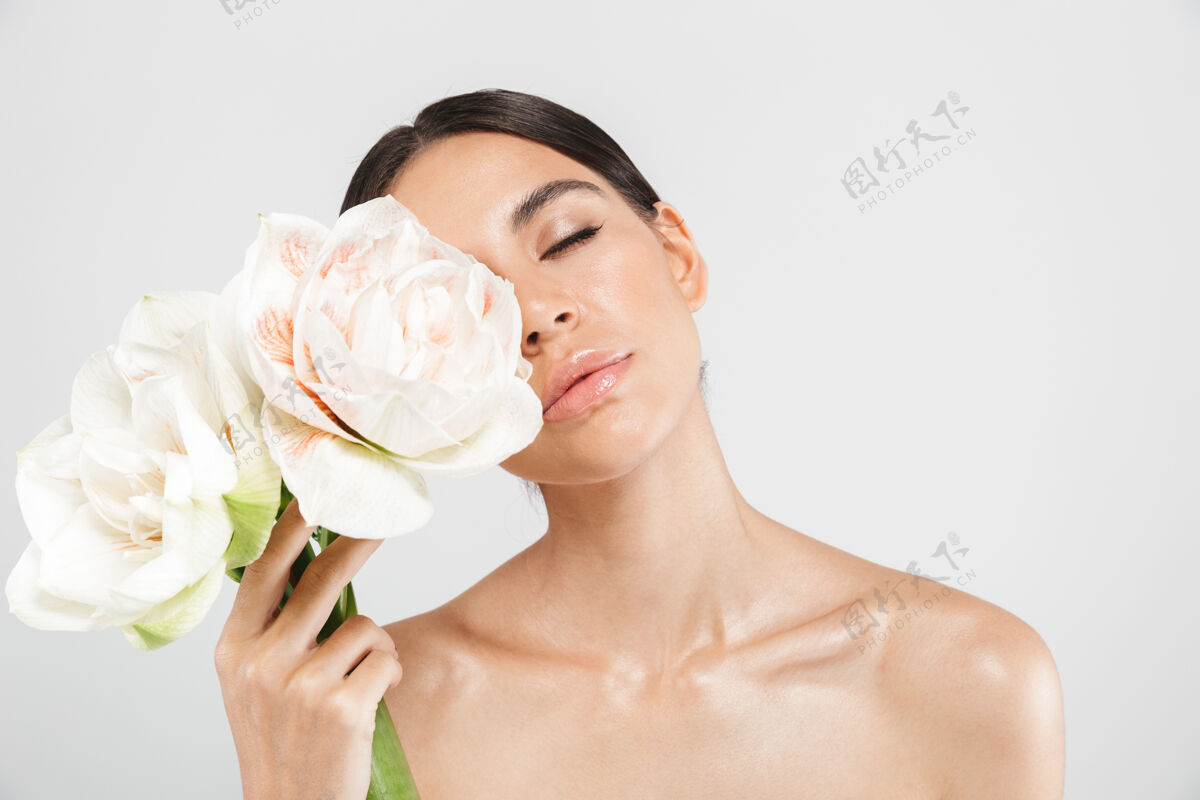 皮肤护理美丽的肖像一个迷人的感官健康的女人站在隔离的白色墙壁 摆出一朵花白种人吸引力看起来