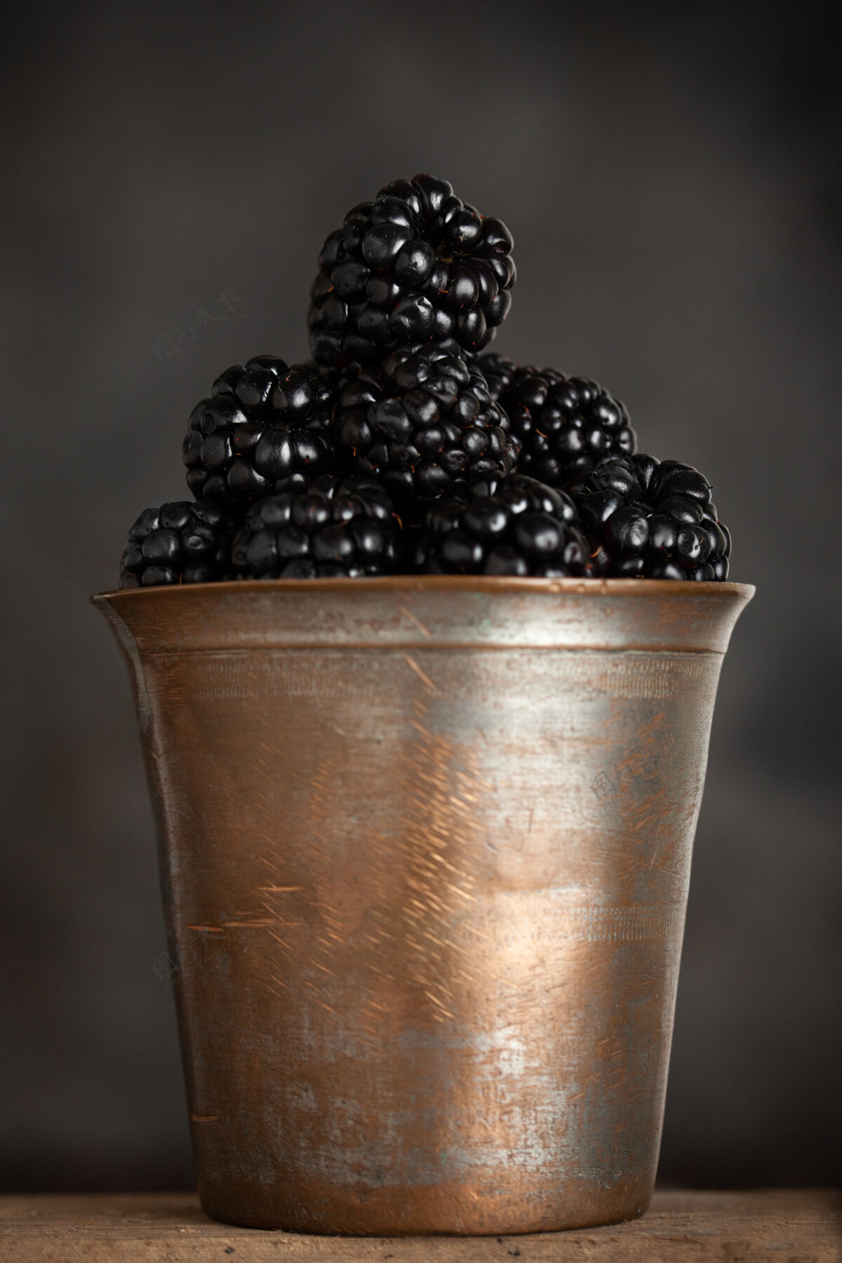 新鲜新鲜黑莓放在天然木质背景上的古铜碗里生的很多配料