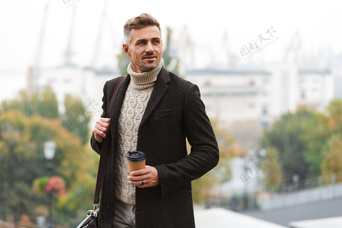 茶穿着夹克的帅哥走在户外 手里拿着一杯外卖咖啡成人街道风格