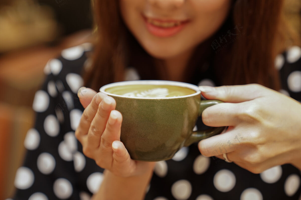 享受热拿铁咖啡在亚洲女孩手里 贴好就可以喝了色调食物情感