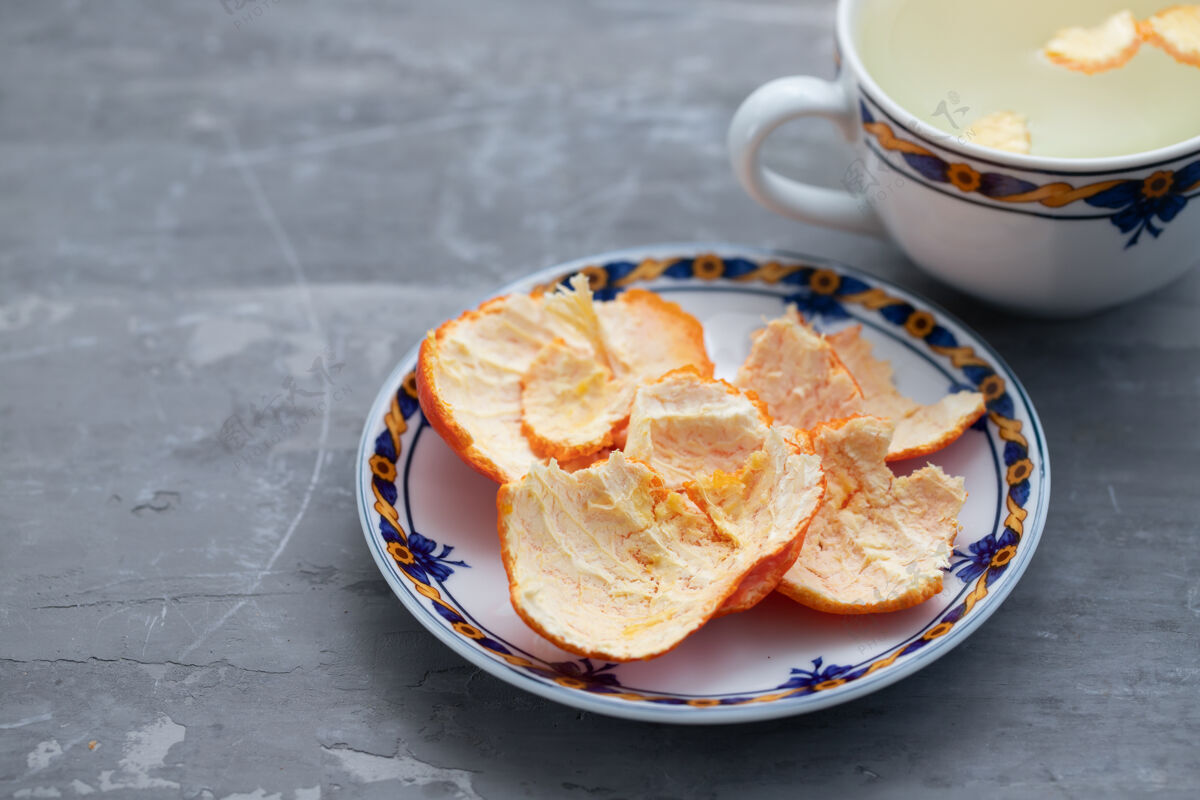 柑橘把桔皮放在盘子里和热水杯里自然美丽健康