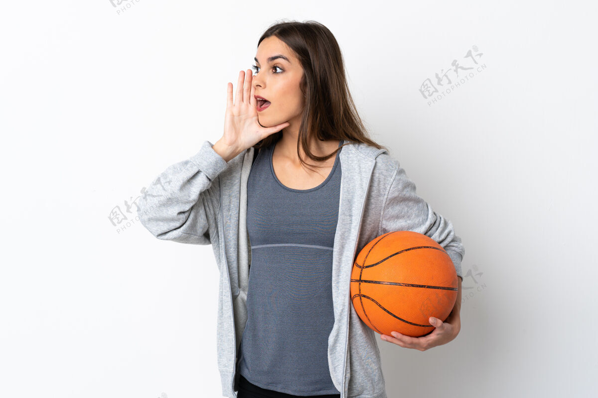 声音打篮球的年轻女子张大嘴巴在白色的地板上大声喊叫专业运动员喊叫