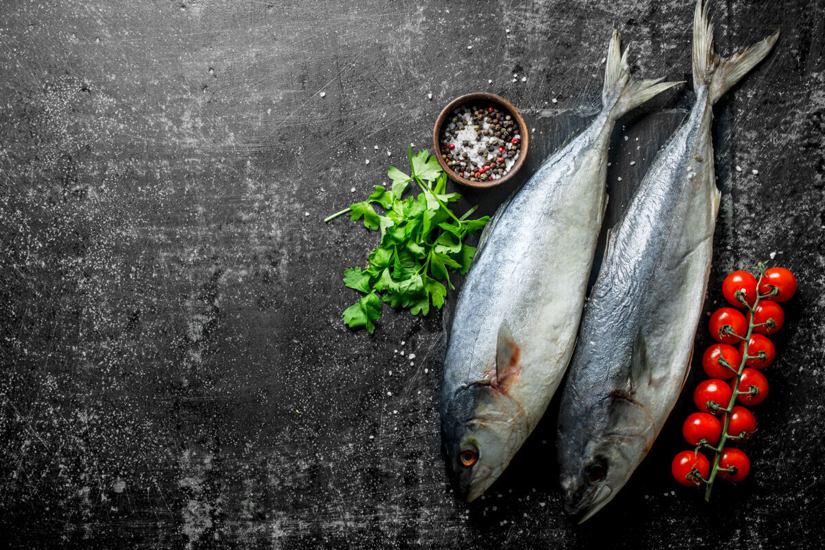 渔业生鱼配欧芹 西红柿和香料放在乡村餐桌上食物海鲜营养