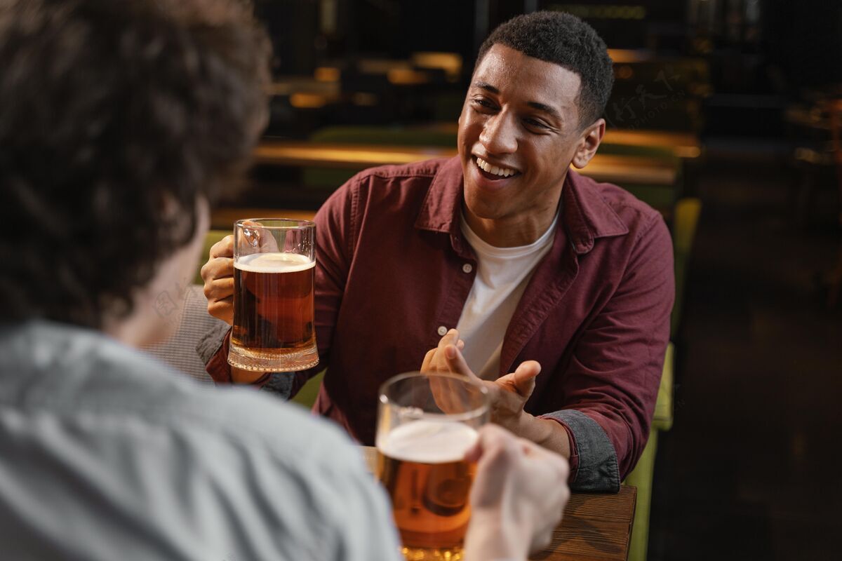 特写用啤酒把酒吧里的男人关起来乐趣啤酒饮料