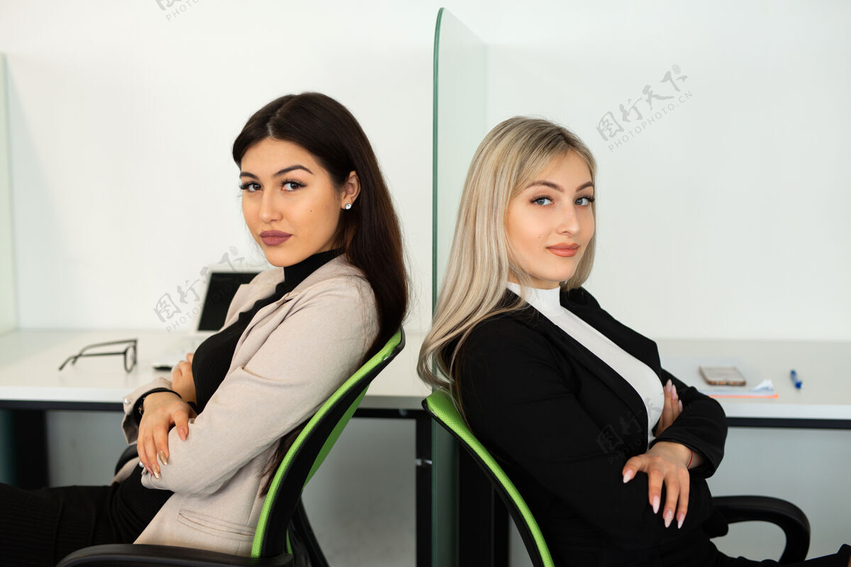 中国人办公室里有两个漂亮的年轻女人操作员女人微笑
