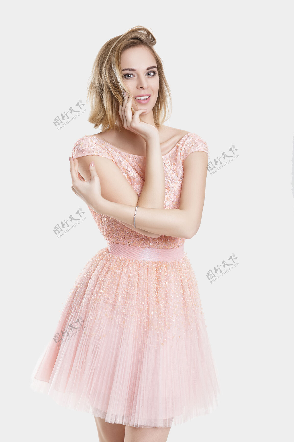 脸在灰色背景下 身着粉红色鸡尾酒裙的金发性感少女微笑的肖像女士女孩女