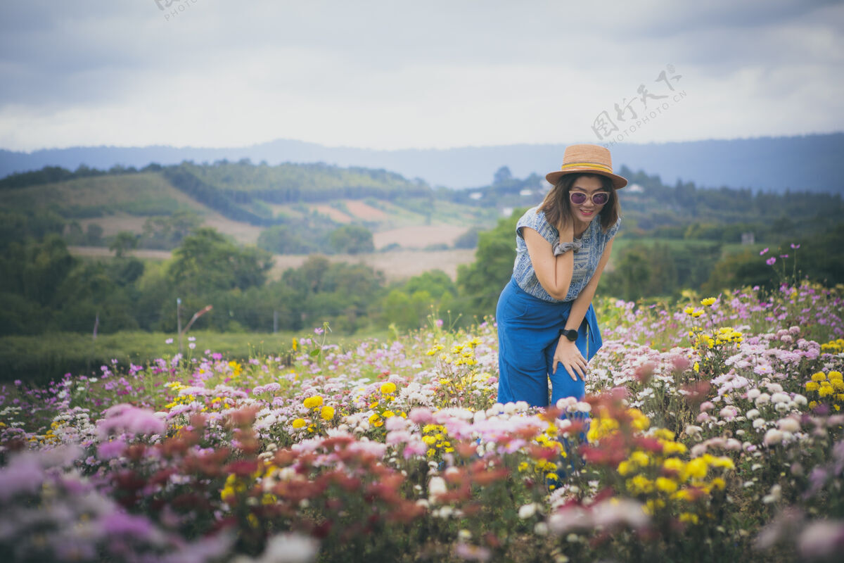 女孩美丽的女人站在盛开的花园里白天年轻草