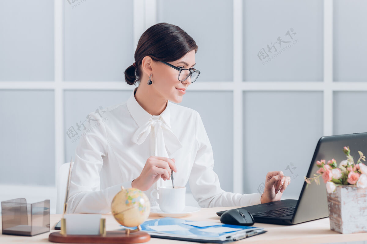 互联网漂亮的女商人在办公室办公桌旁工作一人通信专业人士