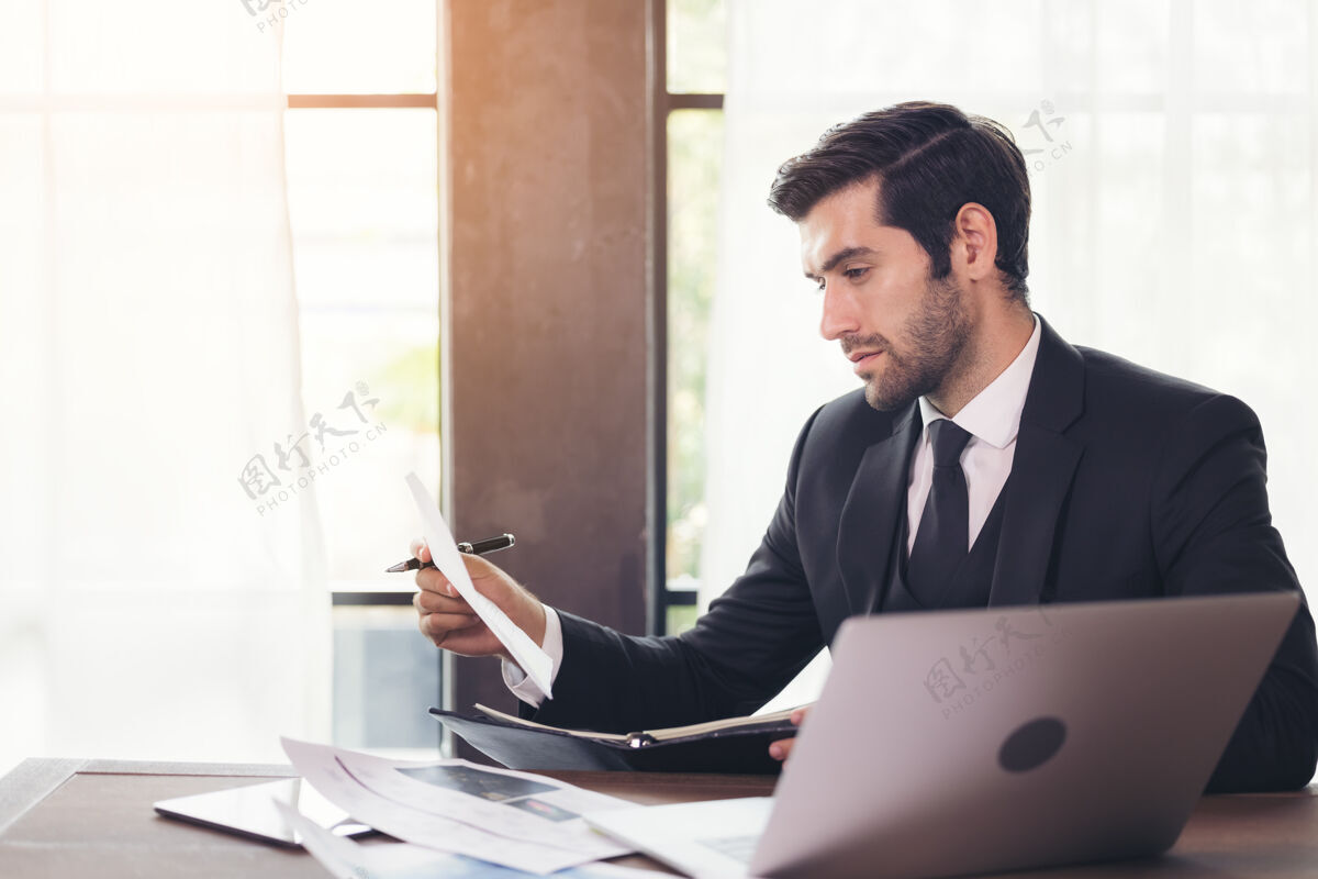 职业年轻商人坐在办公室办公桌旁使用电脑的侧视图Pc电子邮件计算机