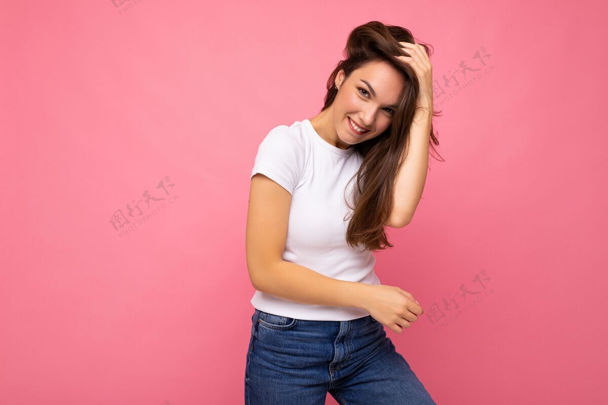 成人正面开朗时尚女性肖像 穿着休闲白色t恤 用于实体模型 粉色背景 带复印空间快乐白色T恤微笑