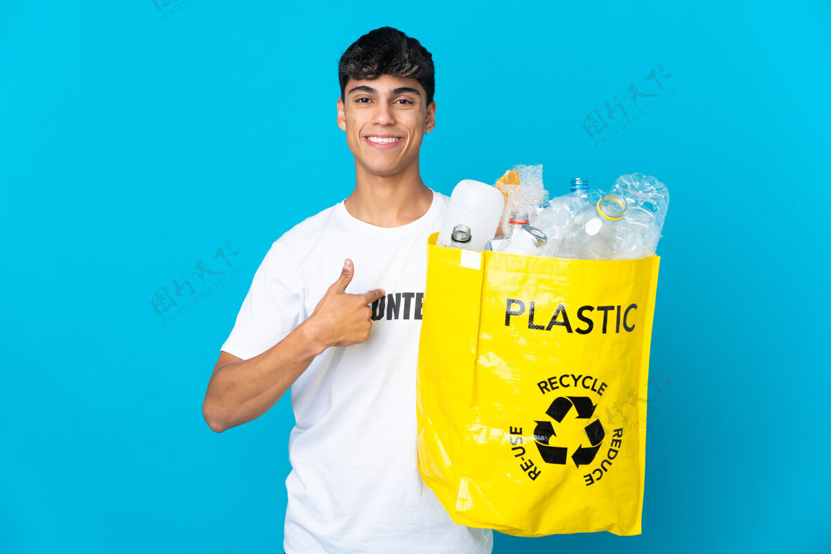 环境拿着装满塑料瓶的袋子在蓝色背景上回收 脸上露出惊讶的表情浪费垃圾环境
