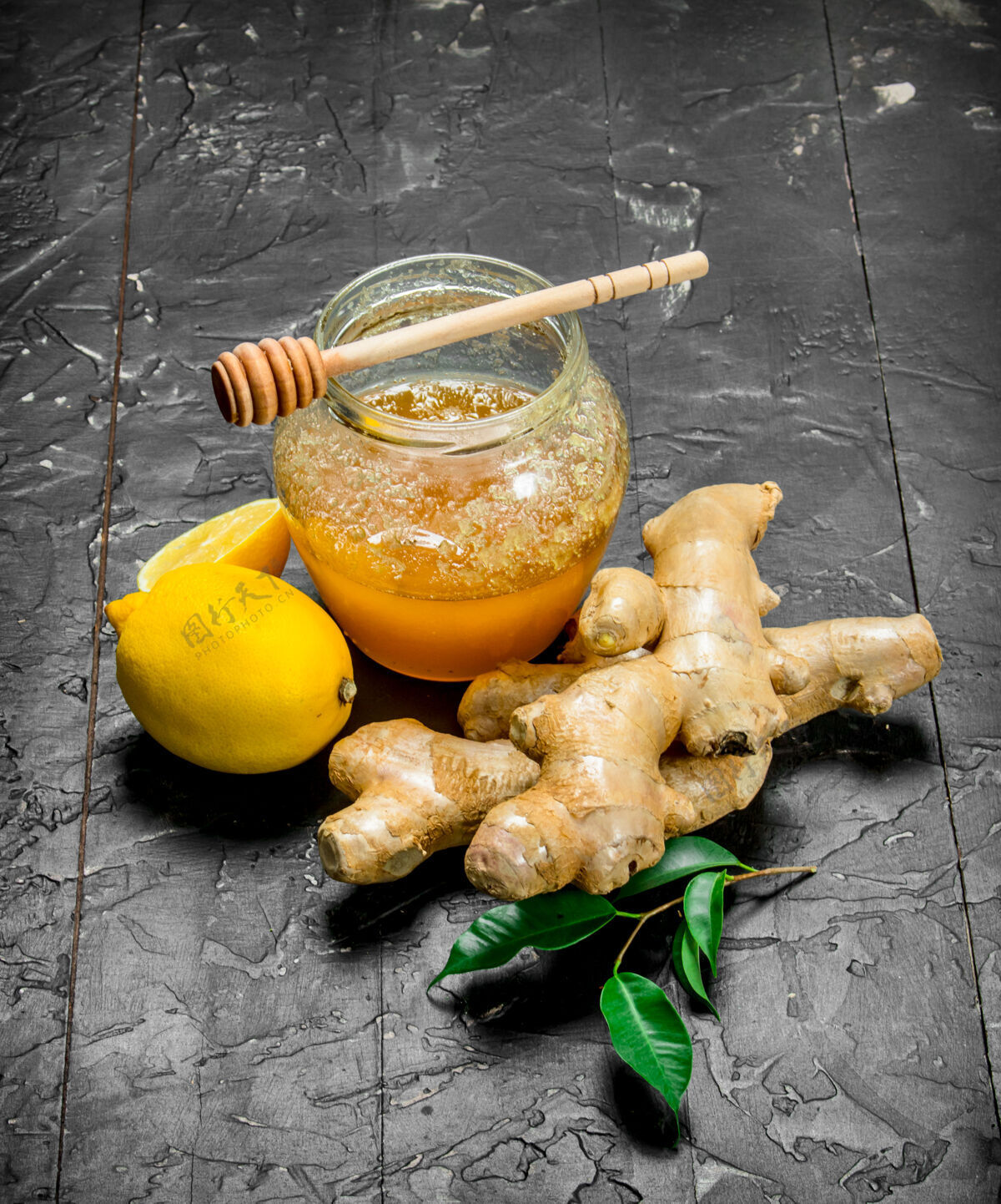 维生素黑木桌上的柠檬蜂蜜姜根香料叶
