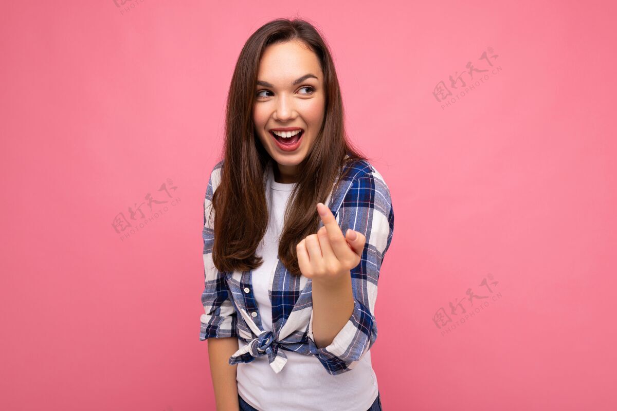 手指拍摄成人快乐微笑美丽的深肤色女人真诚的情感穿着时尚的格子衬衫隔离在粉红色背景与空白空间格子衬衫手势年轻